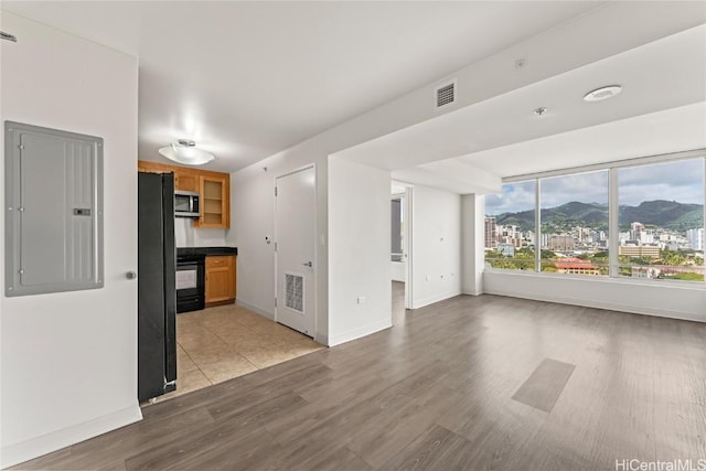 interior space featuring light wood-style floors, electric panel, visible vents, and a mountain view