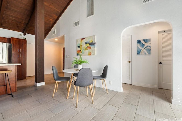 dining area with visible vents, arched walkways, wooden ceiling, beamed ceiling, and wood tiled floor