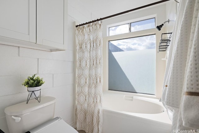 bathroom with shower / tub combo and toilet