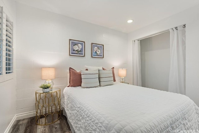 bedroom with baseboards, wood finished floors, and recessed lighting