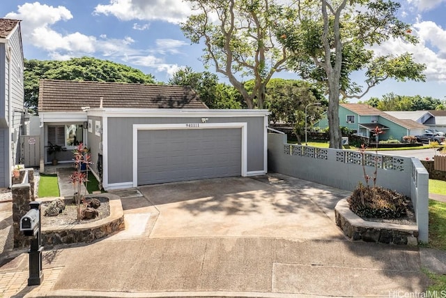 garage with fence and concrete driveway