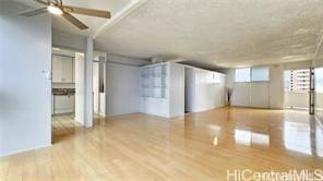 spare room featuring wood finished floors and a ceiling fan