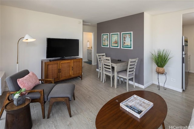 living area with baseboards and light wood finished floors