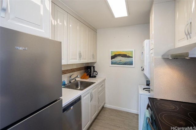 kitchen featuring stainless steel appliances, light countertops, light wood-style floors, white cabinetry, and a sink