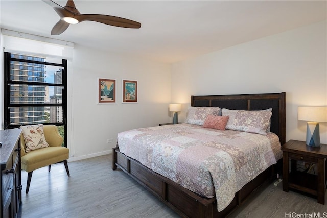 bedroom featuring ceiling fan, wood finished floors, and baseboards