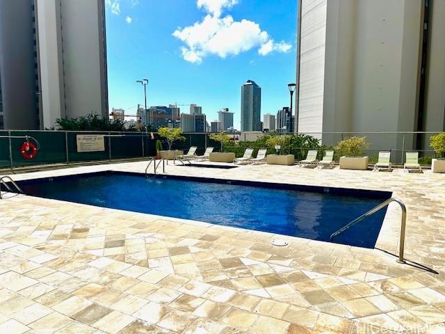 community pool with a view of city and a patio area