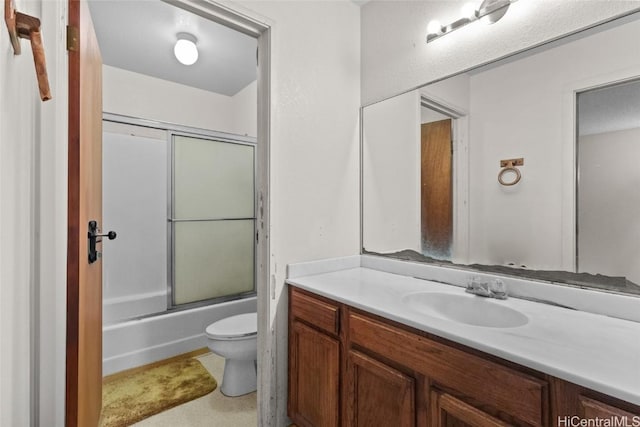 full bath featuring toilet, bath / shower combo with glass door, and vanity