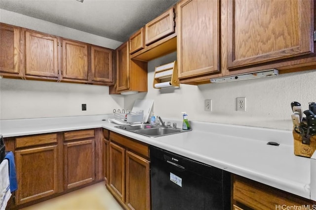 kitchen with brown cabinets, light countertops, dishwasher, and a sink