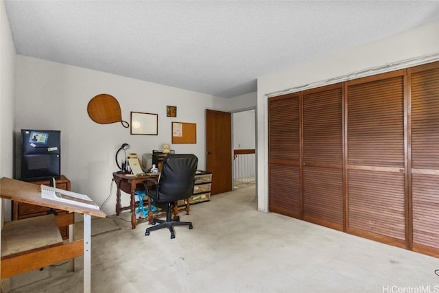 office area with carpet floors and a textured ceiling