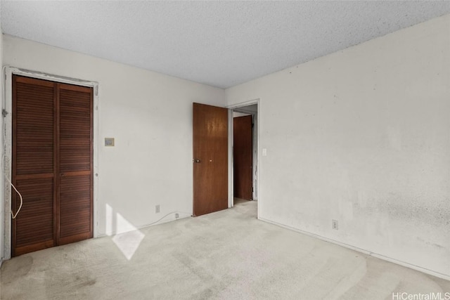 unfurnished bedroom featuring a textured ceiling, carpet floors, and a closet