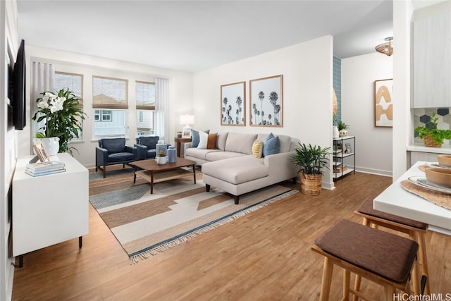 living area featuring baseboards and wood finished floors