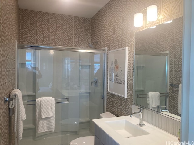 bathroom with toilet, a stall shower, and vanity