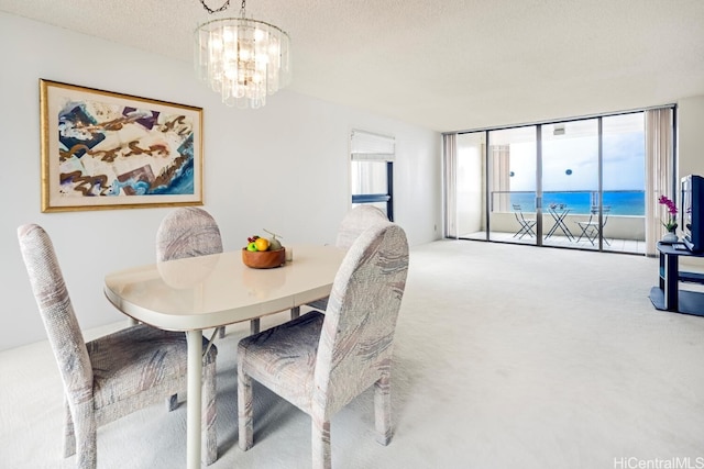 dining space featuring a chandelier, carpet floors, a textured ceiling, and floor to ceiling windows