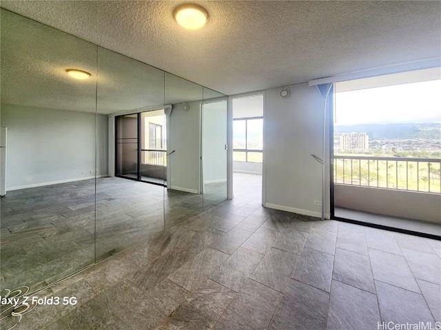 spare room with baseboards and a textured ceiling