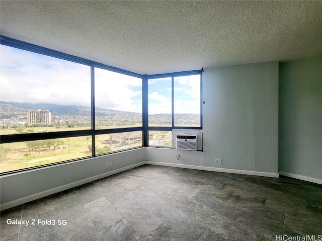 unfurnished room with baseboards and a textured ceiling