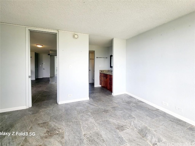 interior space featuring baseboards and a textured ceiling