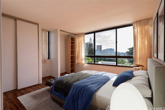 bedroom featuring a view of city and wood finished floors