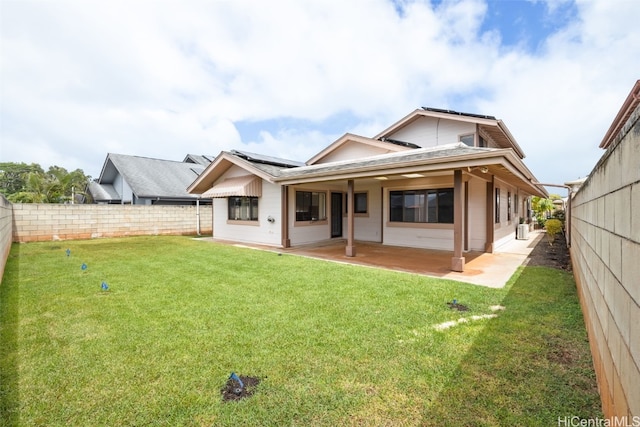 back of property with a lawn, a fenced backyard, and a patio area