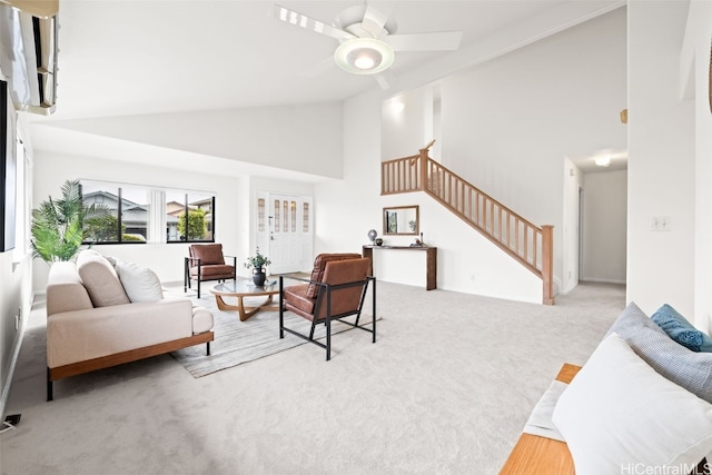 carpeted living room featuring stairway, high vaulted ceiling, and ceiling fan