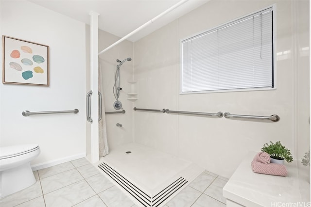 full bathroom featuring a shower stall, toilet, baseboards, and tile patterned floors