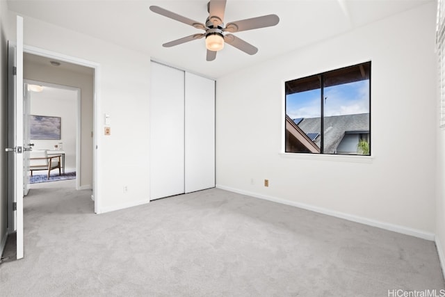 unfurnished bedroom with a ceiling fan, carpet, a closet, and baseboards