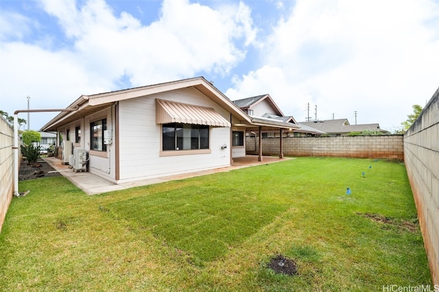 rear view of house featuring a patio area, a lawn, and a fenced backyard