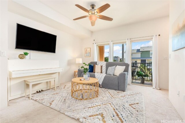 carpeted living area featuring ceiling fan