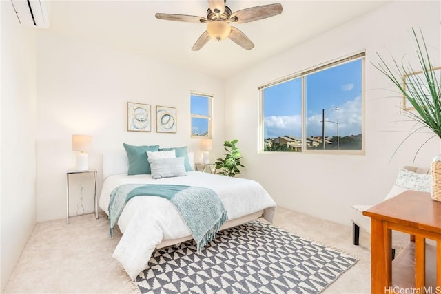 carpeted bedroom featuring a wall mounted air conditioner and ceiling fan