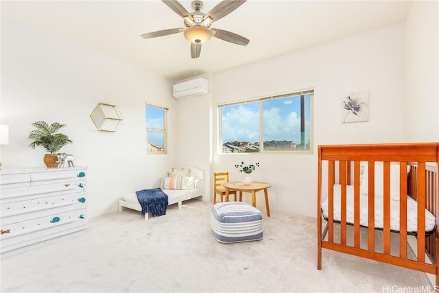 carpeted bedroom featuring a crib, ceiling fan, and a wall mounted AC