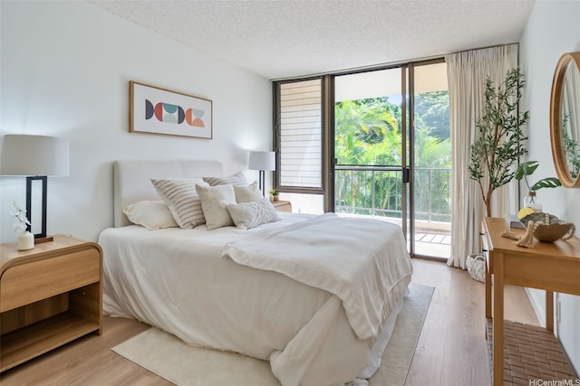 3138 Waialae Ave Unit 217, Honolulu, HI 96816 - bedroom with expansive windows, access to outside, light wood-type flooring, and a textured ceiling