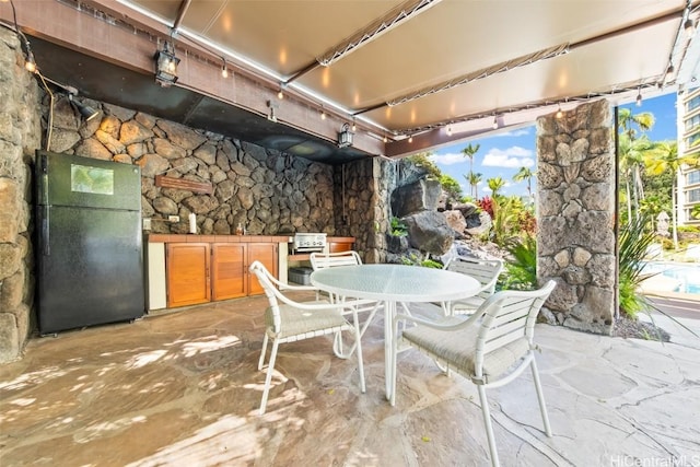 view of patio featuring outdoor dining area and an outdoor kitchen