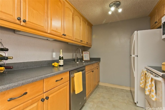 kitchen with a sink, a textured ceiling, dark countertops, white appliances, and brown cabinetry