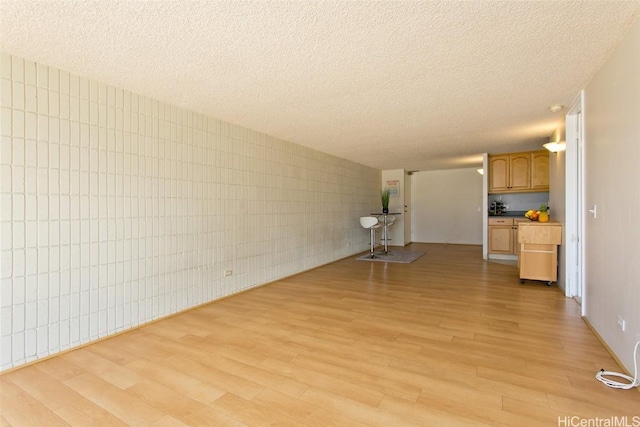 unfurnished living room featuring light wood-style floors and a textured ceiling