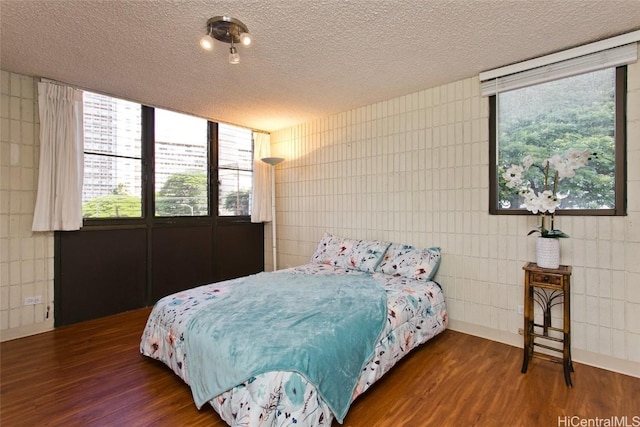 bedroom featuring wood finished floors and a textured ceiling