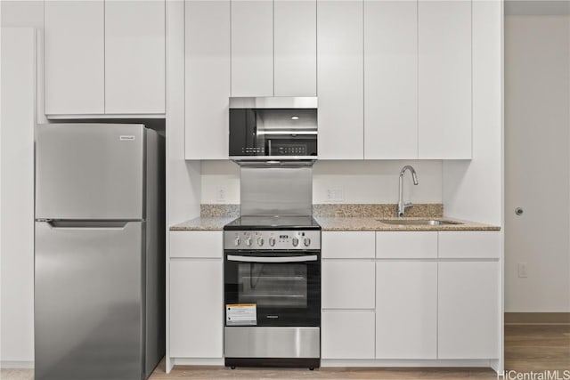 kitchen featuring white cabinets, stainless steel appliances, modern cabinets, and a sink