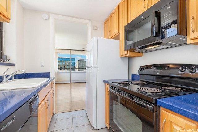 kitchen featuring light brown cabinets, light tile patterned flooring, a sink, black appliances, and dark countertops