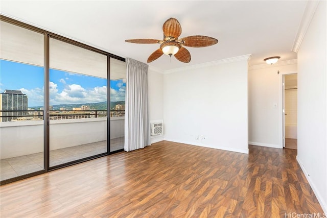 spare room with crown molding, baseboards, a wall unit AC, wood finished floors, and a ceiling fan