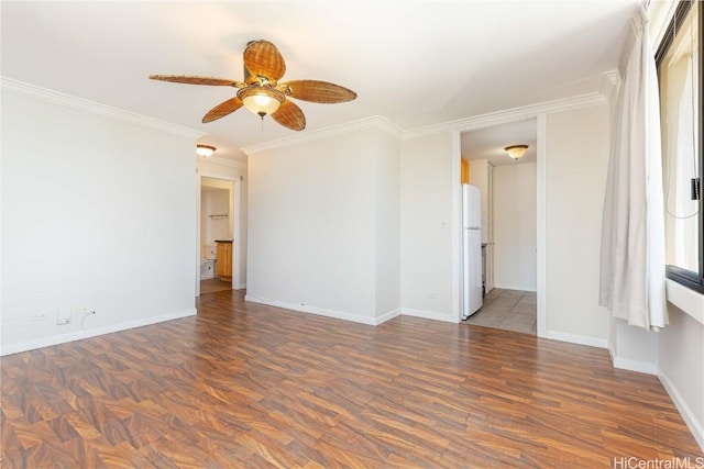 empty room featuring ceiling fan, crown molding, and baseboards