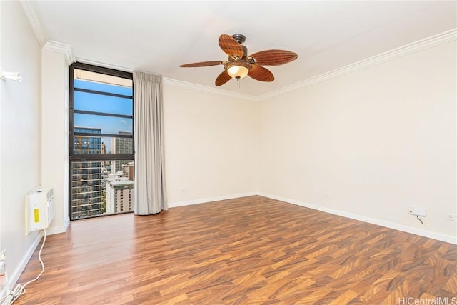 empty room with baseboards, a ceiling fan, floor to ceiling windows, and crown molding