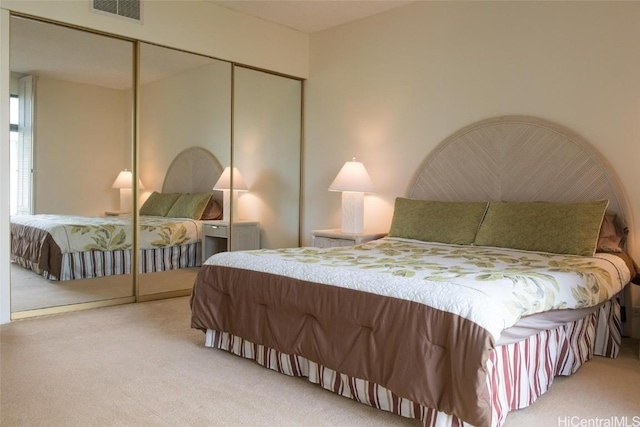 carpeted bedroom featuring a closet and visible vents