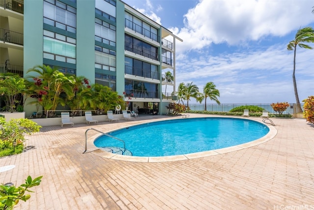 community pool with a patio and fence