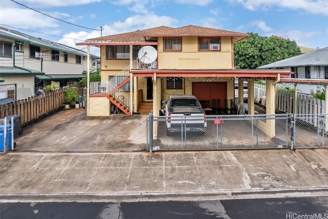 view of front of house with stairway, fence, and driveway