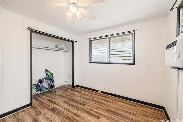 unfurnished bedroom featuring a ceiling fan, wood finished floors, a closet, and baseboards