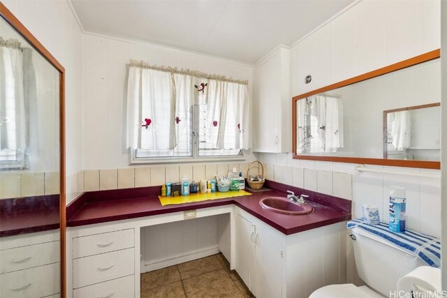 bathroom with toilet, ornamental molding, backsplash, tile patterned flooring, and vanity