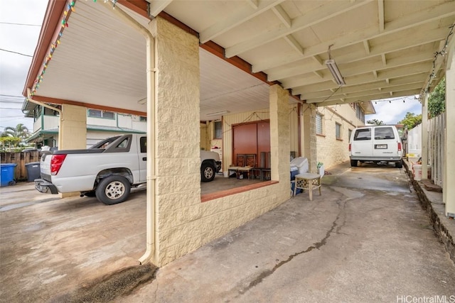 view of car parking featuring a carport and fence