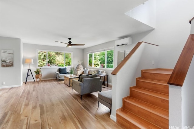 living area with light wood-style flooring, baseboards, stairs, and a wall unit AC