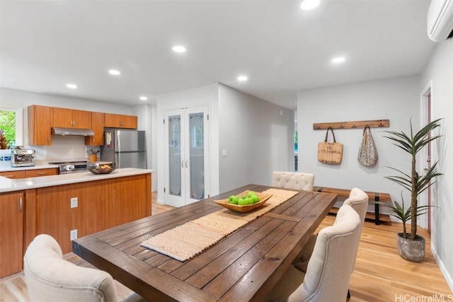 dining space with baseboards, a wall mounted air conditioner, light wood-type flooring, recessed lighting, and french doors