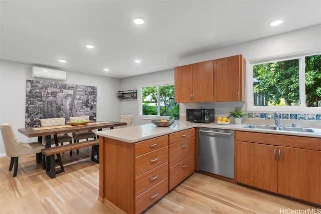 kitchen featuring a peninsula, a sink, an AC wall unit, black microwave, and dishwasher