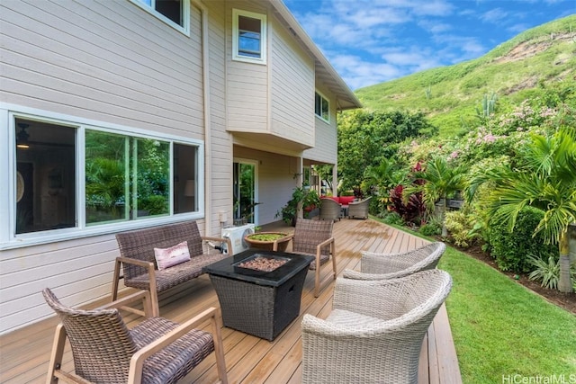 wooden deck with a mountain view and an outdoor fire pit