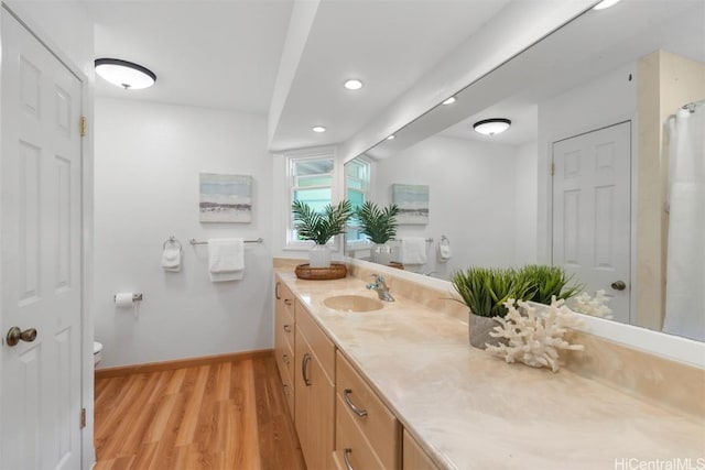 full bathroom featuring vanity, wood finished floors, baseboards, recessed lighting, and toilet